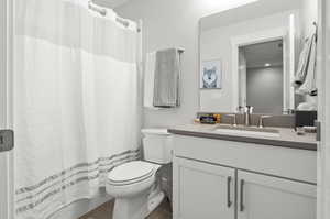 Bathroom featuring tile flooring, toilet, and large vanity