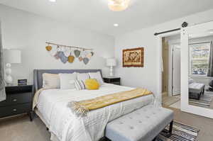 Bedroom featuring carpet and a barn door