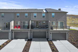 View of property with a balcony and a garage