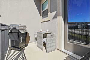 View of patio with a grill and a balcony