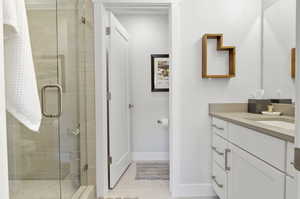 Bathroom featuring an enclosed shower, tile floors, and vanity