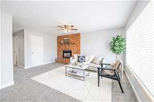 Living room with ceiling fan, carpet, and a brick fireplace