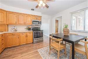Kitchen featuring appliances with stainless steel finishes, light hardwood / wood-style flooring, and ceiling fan