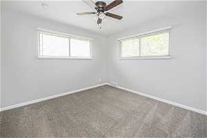 Empty room with ceiling fan and carpet