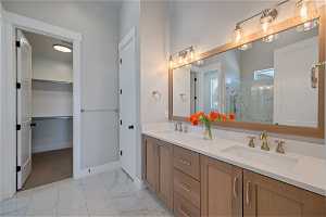 Bathroom featuring a shower, double sink, tile flooring, and oversized vanity