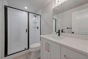 Bathroom featuring large vanity, an enclosed shower, tile floors, and toilet