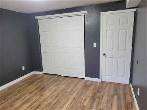 Unfurnished bedroom featuring hardwood / wood-style flooring and a closet