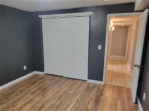 Unfurnished bedroom featuring a closet and hardwood / wood-style floors