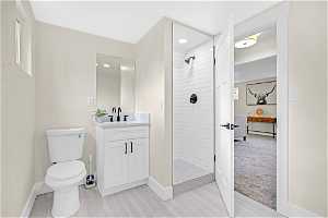 Bathroom with vanity, toilet, and tiled shower