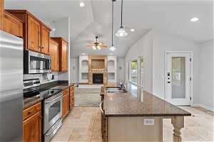 Kitchen featuring sink, ceiling fan, light tile flooring, and stainless steel appliances