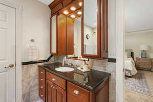 Primary ensuite bathroom with tile walls, Italian marble tile walls and backsplash, and vanity