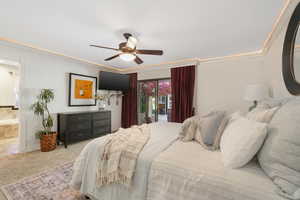 Primary bedroom featuring ensuite bath, ceiling fan, and access to exterior