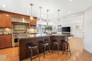 Kitchen with a wall chimney exhaust hood, and a kitchen island