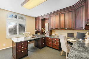 Home office space with cherry wood cabinets and granite working spaces.