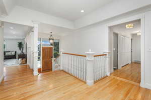 Foyer entrance with light hardwood, decorative columns, and a wealth of natural light