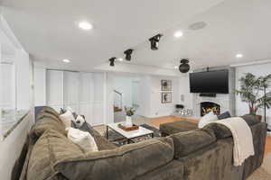 Family room featuring brick wall, a brick fireplace, and hardwood / wood-style floors