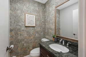 Half bathroom with large vanity and toilet