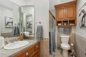 Bathroom featuring vanity with cabinet space, toilet,and  tile flooring