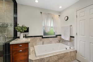 Primary ensuite bathroom with walk in shower and bathtub