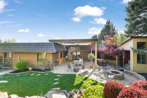 Rear view of property featuring a patio area, a fire pit, a yard, and a pergola