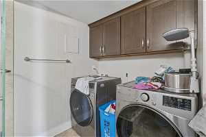 Laundry area featuring independent washer and dryer and cabinets