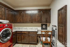 Washroom with cabinets, washer / dryer, and light tile flooring