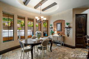 Tiled dining space with beam ceiling and a notable chandelier