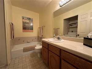 Bathroom with a bath, washer / dryer, toilet, and vanity