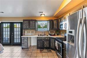 Kitchen featuring a wealth of natural light, dark brown cabinetry, sink, and stainless steel appliances