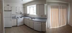 Kitchen with white cabinets, white appliances, sink, and light tile floors