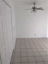 Tiled empty room featuring ceiling fan