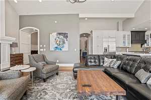 Living room with beamed ceiling, high vaulted ceiling, and light hardwood / wood-style flooring