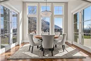 Sunroom / solarium with a notable chandelier, a wealth of natural light, and a mountain view