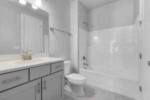 Full bathroom with tile patterned floors, vanity, shower / bathing tub combination, and toilet