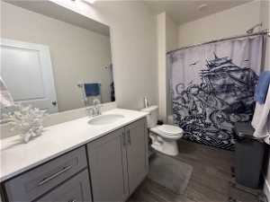 Bathroom featuring toilet, vanity with extensive cabinet space, and hardwood / wood-style flooring