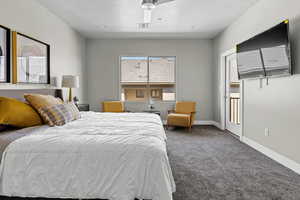 Bedroom with ceiling fan and dark carpet