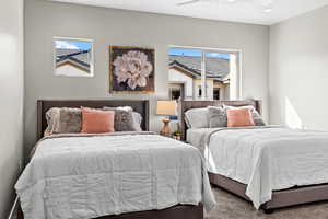 Bedroom with carpet flooring, ceiling fan, and multiple windows