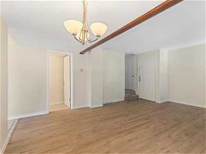 Spare room featuring light hardwood / wood-style flooring and a notable chandelier