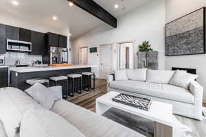 Living room featuring high vaulted ceiling, beam ceiling.