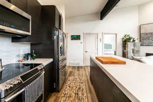 Kitchen with appliances with stainless steel finishes, and lofted ceiling with beams