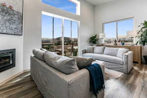 Living room with plenty of natural light, dark wood-type flooring, and a towering ceiling