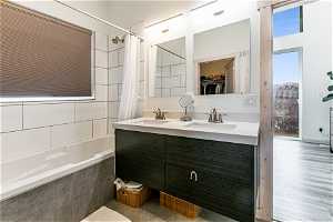 Bathroom with shower / tub combo, dual bowl vanity.
