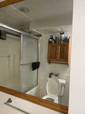 Bathroom with toilet and tile walls