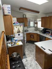 Kitchen with sink, appliances with stainless steel finishes, light tile flooring, and tasteful backsplash