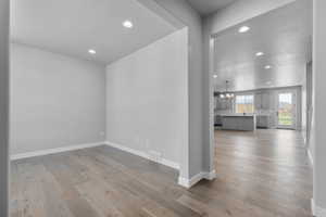 Empty room featuring sink, light hardwood / wood-style flooring, and an inviting chandelier