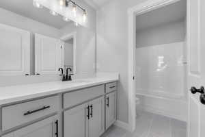 Full bathroom with shower / bathtub combination, vanity, tile patterned flooring, and toilet