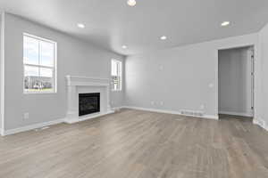 Unfurnished living room featuring a textured ceiling and light wood-type flooring