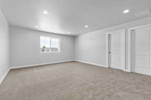 Unfurnished room featuring carpet flooring and a textured ceiling