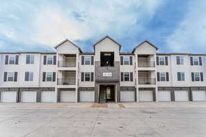 View of property with a balcony and a garage