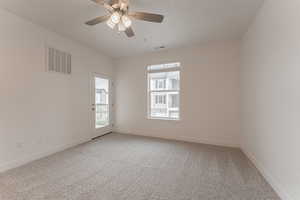 Carpeted spare room with ceiling fan and a healthy amount of sunlight